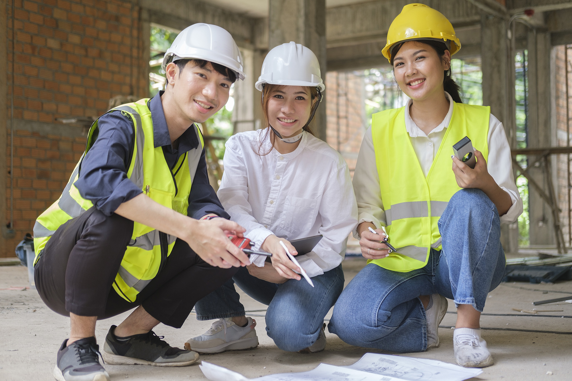 Team of three young asian engineers discussing a project